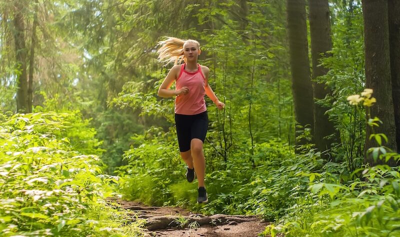 Kvinna som springer i naturen