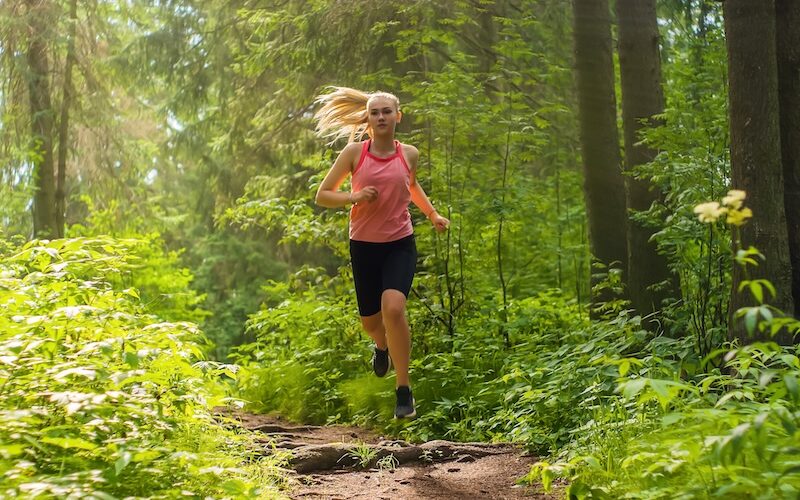 Kvinna som springer i naturen